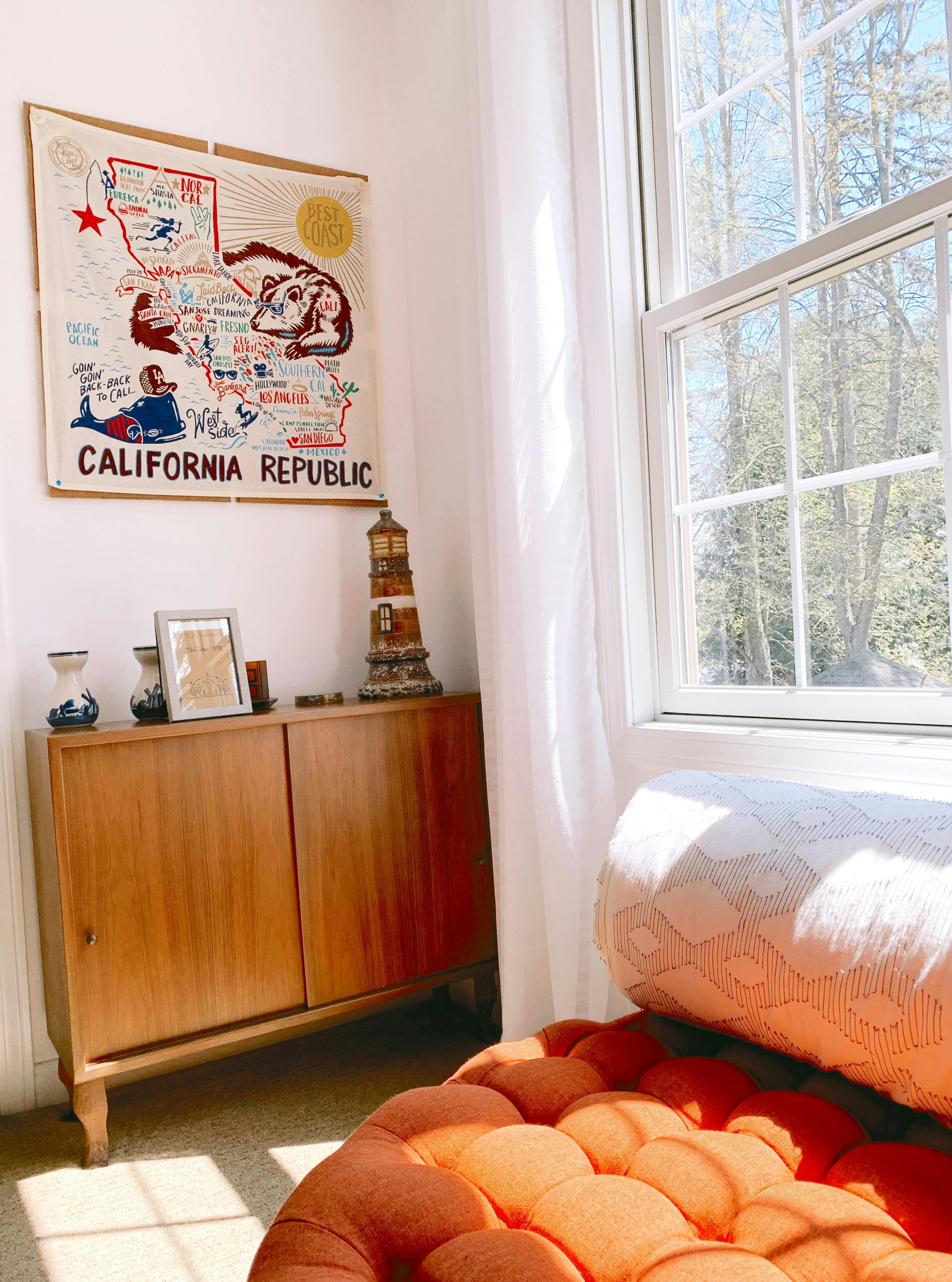 Sunlit corner of a living room with California Republic art and cozy seating.