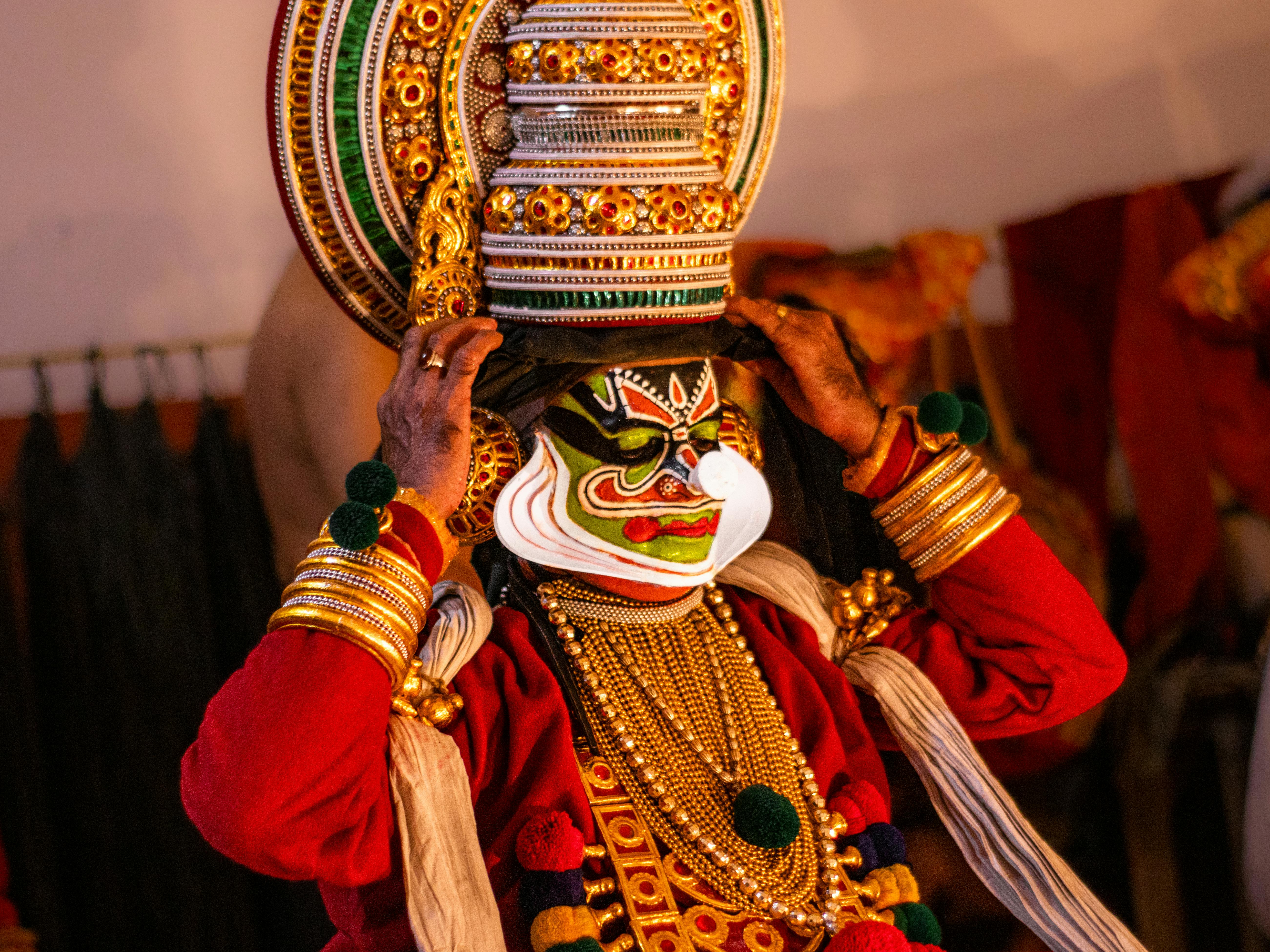 Gratuit O interpretă Kathakali îmbrăcată în ținute tradiționale și machiată în culise, surprinzând esența dansului clasic indian. Fotografie de stoc