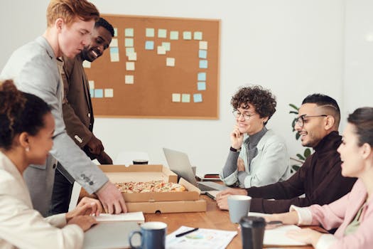 Diverse team enjoying a brainstorming session over pizza during a business meeting.