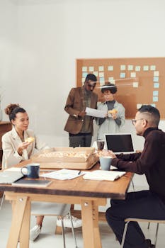 一群同事在披萨休息时间，一边享用披萨一边讨论现代办公室的工作