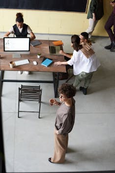 High angle view of a diverse team collaborating in an open office space with laptops and documents.