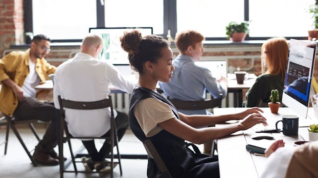 A diverse group of professionals working together in a modern office environment, focused on teamwork.