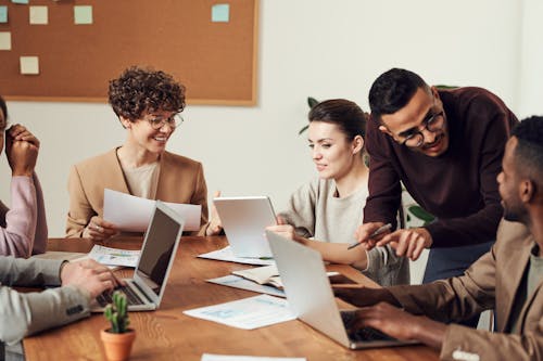 Free Group of People Gathered Around Wooden Table Stock Photo