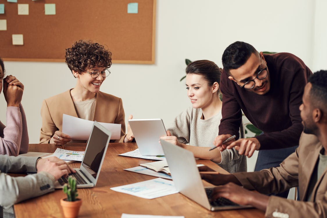 Free Group of People Gathered Around Wooden Table Stock Photo