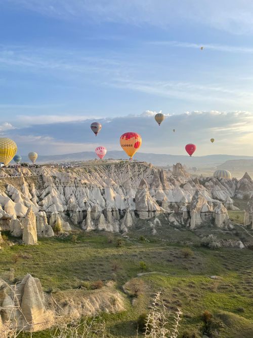 Free Breathtaking view of hot air balloons floating over Cappadocia's fairy chimneys at sunrise. Stock Photo