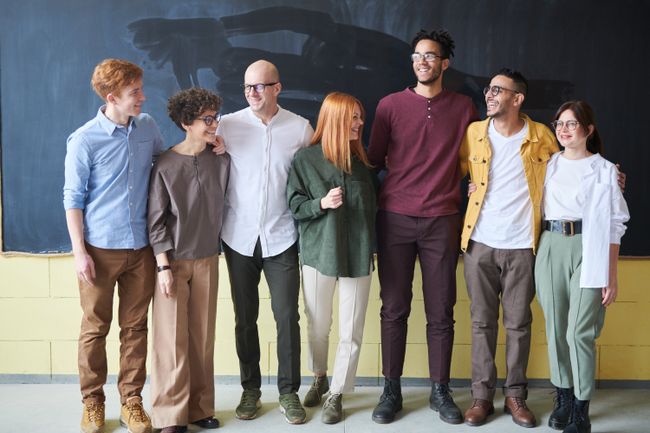 Six colleagues standing together for a group photo. Photo by fauxels on Pexels