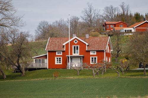 Free Quaint red wooden house in Jönköping, Sweden, showcasing traditional Swedish architecture in rural scenery. Stock Photo