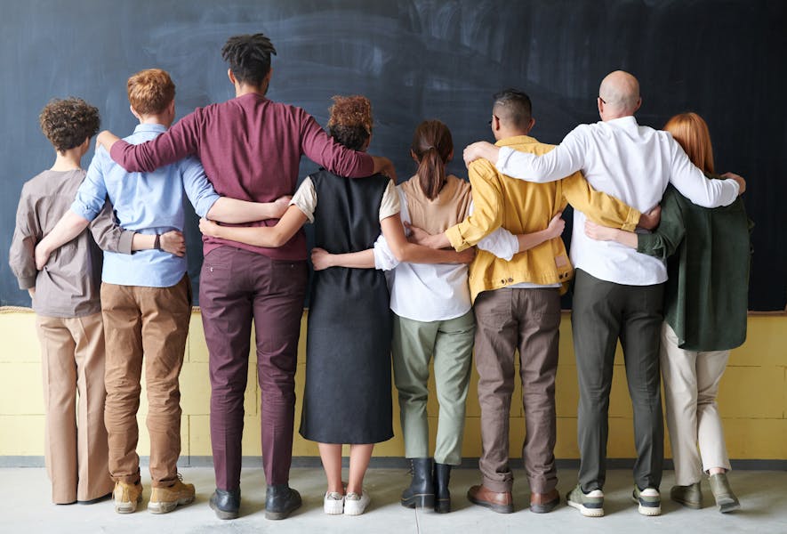 Alone but supported – people facing away with arms around each other