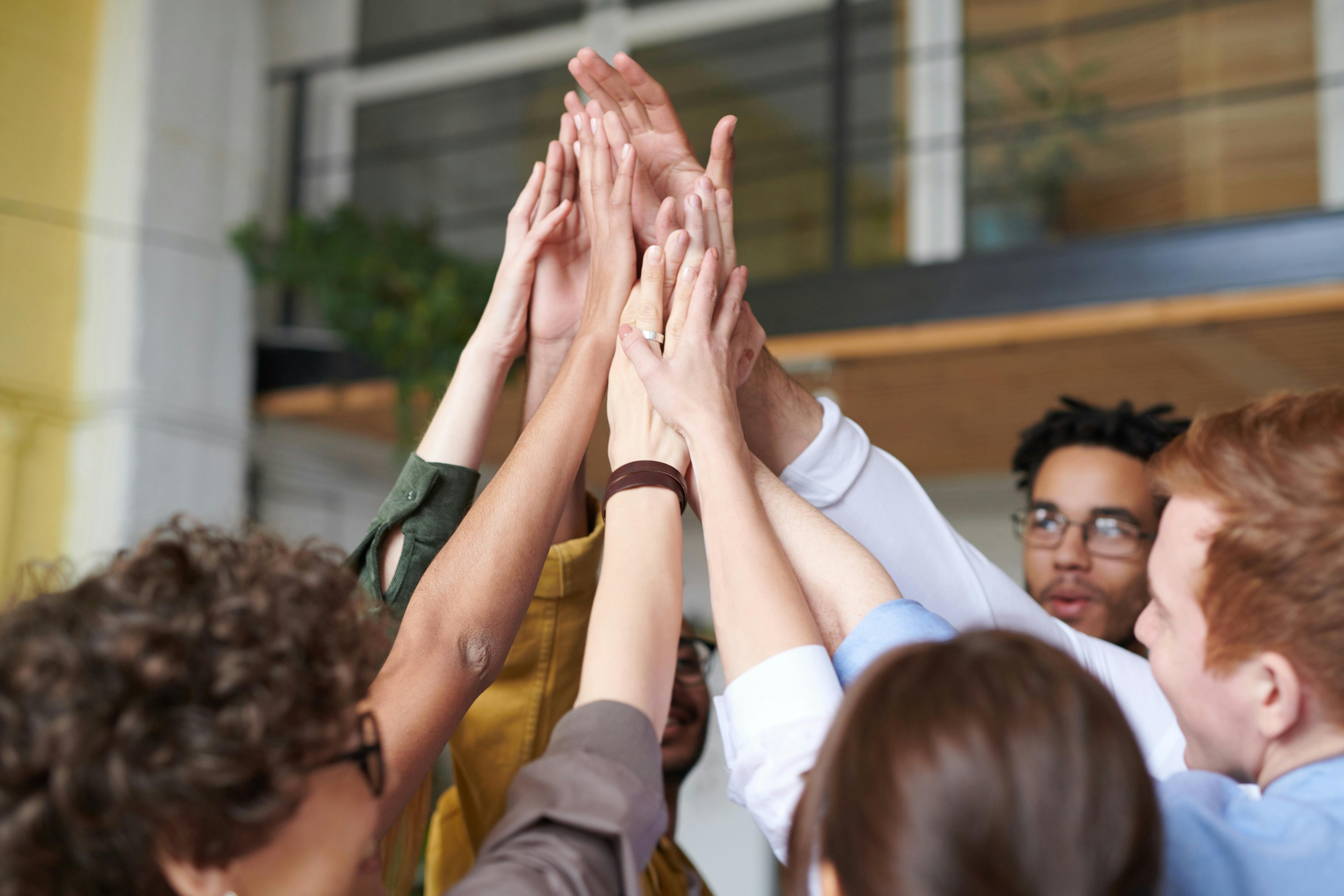 photo of people touching each other s hands