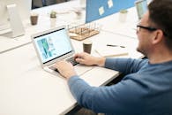 一名成年男子在办公室用笔记本电脑专注地工作