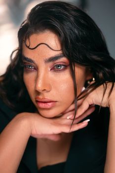 Close-up portrait of a woman with artistic makeup, looking thoughtfully into the distance.