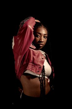 Dynamic studio portrait of a confident black female musician wearing a red leather jacket in Berlin.