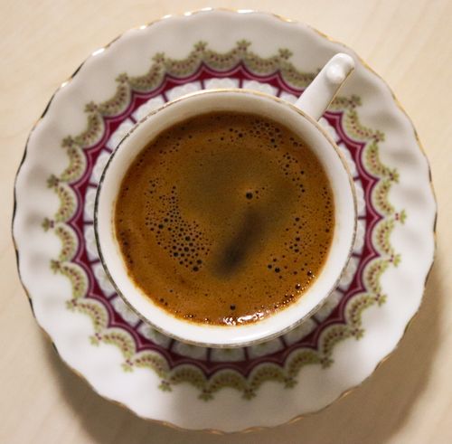 Free Top-down view of a freshly brewed coffee in an ornate cup and saucer, showcasing intricate design. Stock Photo