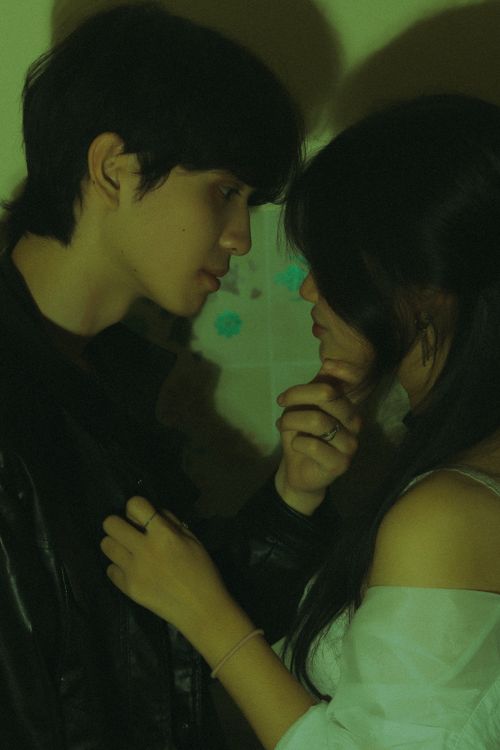 Free Close-up of a young couple sharing an intimate moment in moody, low-light setting. Stock Photo