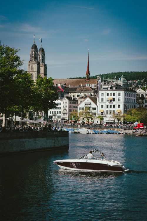 Free Picturesque scene featuring a boat on Lake Zurich with iconic Fraumünster church in the background. Stock Photo