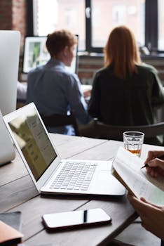 一群在室内工作、与技术合作并为商业项目做笔记的成年人