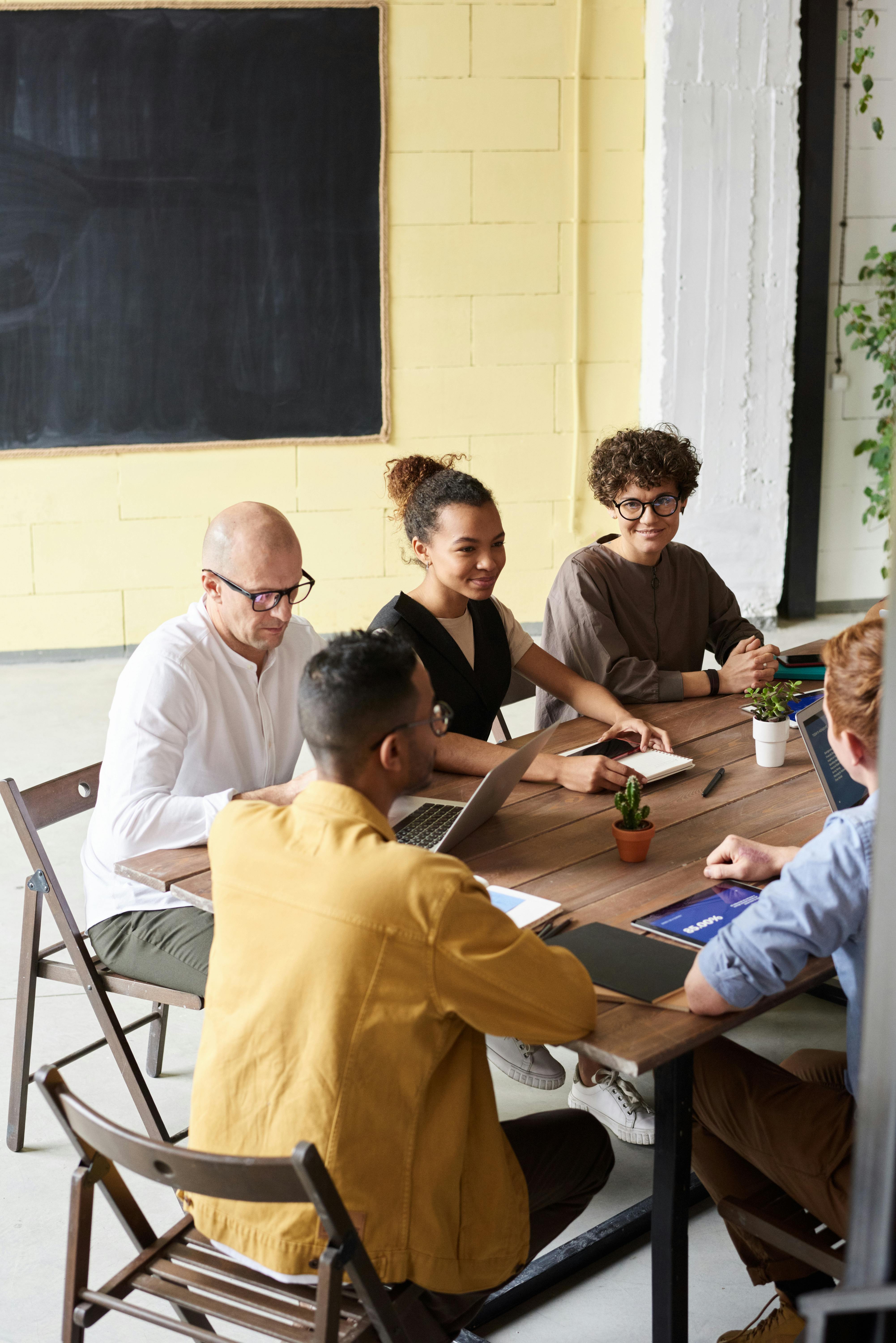 photo of people leaning on wooden table