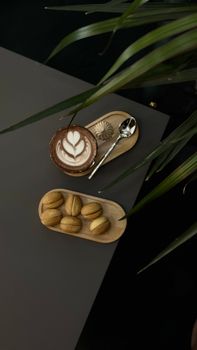 Elegant table setting with coffee and cookies on a dark background, minimalist style.