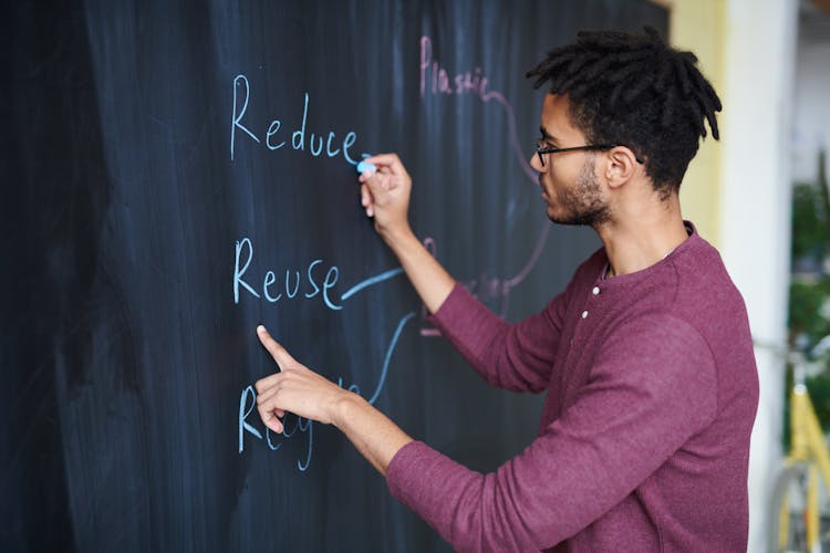 Photo Of Man Writing On Blackboard