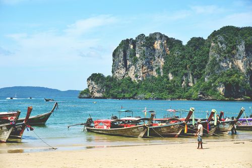 Free Picturesque view of long tail boats on the sandy shores of Ao Nang Beach, Krabi, Thailand. Stock Photo