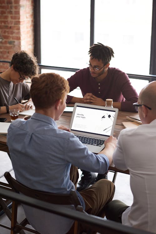 Photo Of People Leaning On Table