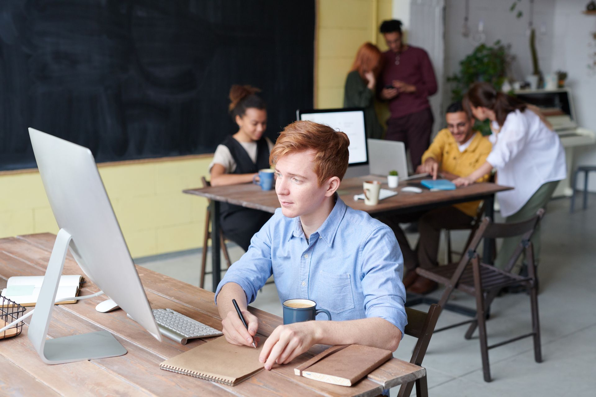 Group of young adults working and collaborating in a modern open office space.