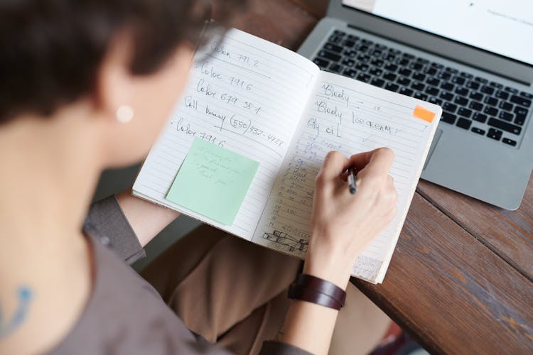 Photo Of Person Writing On Notebook