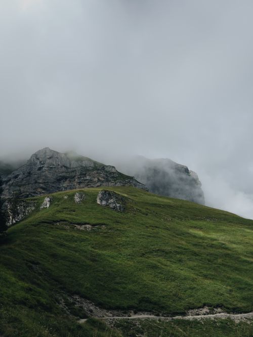Free Fogg-covered mountains and lush green hills create a serene and atmospheric landscape. Stock Photo