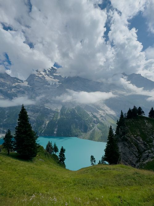 Free Breathtaking view of turquoise lake and mountains under a dramatic cloudy sky. Stock Photo