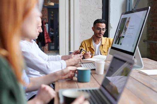 A diverse group of professionals working together in a modern office with laptops and coffee.