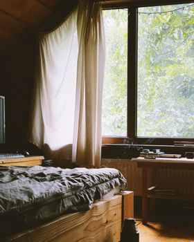 A serene cabin bedroom with natural light streaming through the window.