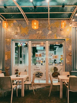 Charming outdoor cafe with mosaic wall and warm lighting, perfect for a cozy evening.