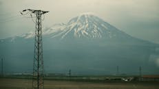 Snow-Capped Mountain with Power Lines in Foreground