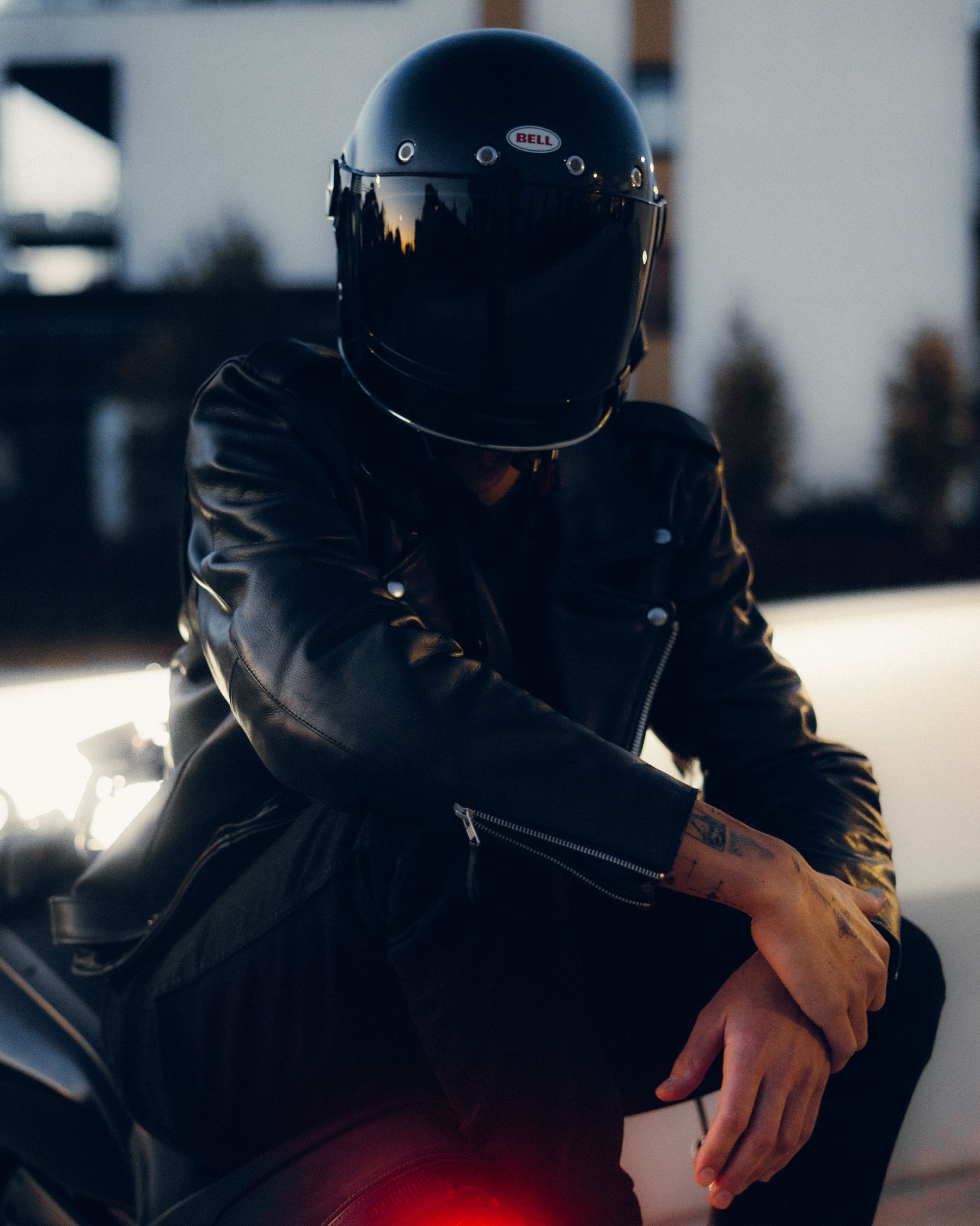 Stylish motorcycle rider wearing a black helmet and black leather riding jacket
