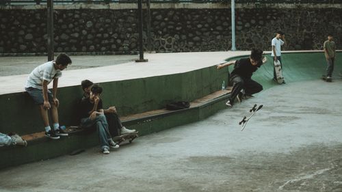Free Teenagers skateboarding and performing tricks in a West Java park. A dynamic and lively urban scene. Stock Photo
