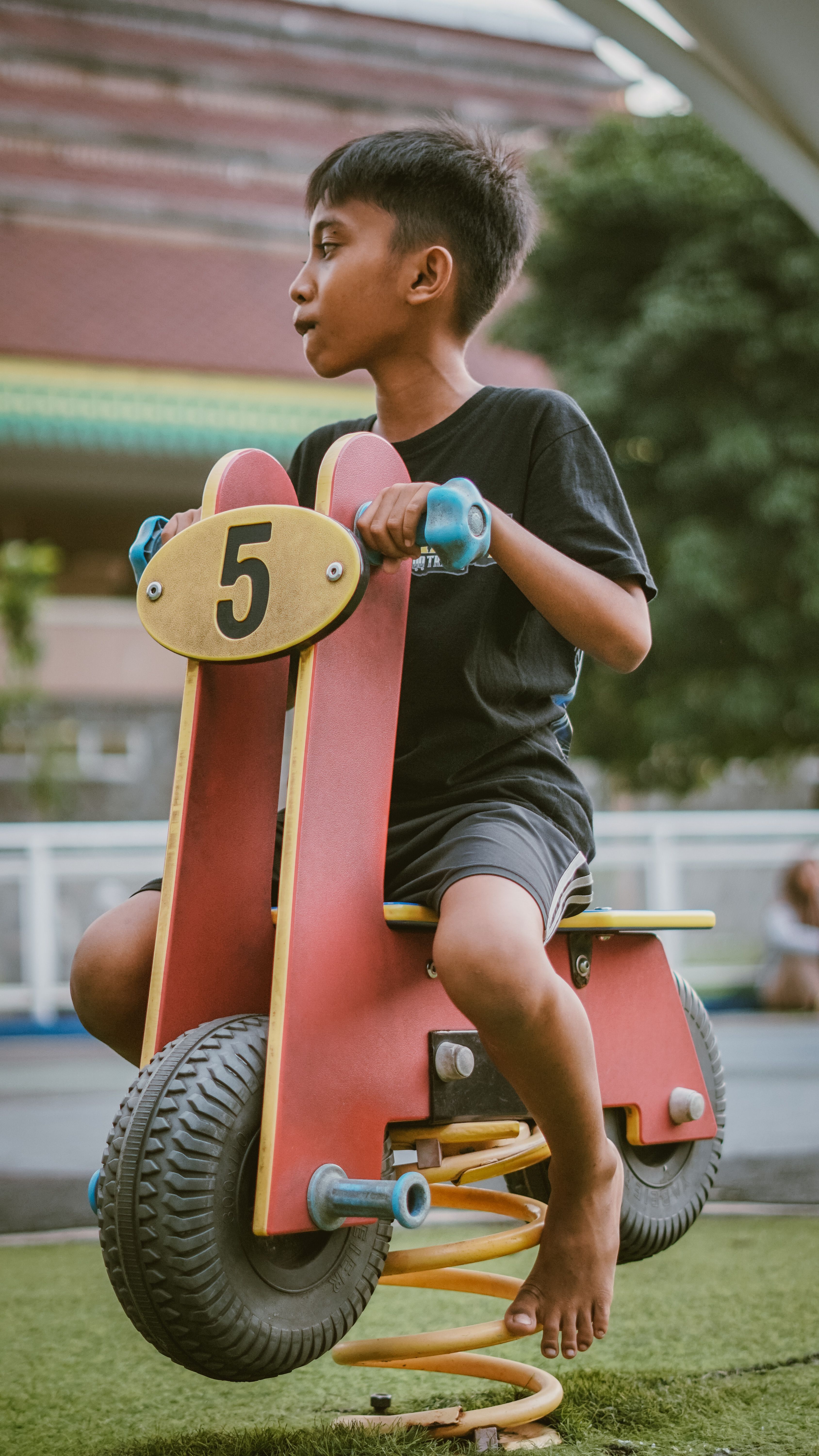 Child Enjoying Spring Rider in Urban Playground · Free Stock Photo