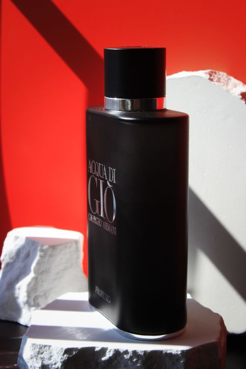 Free Stylish Acqua di Giò bottle set against a bold red backdrop, perfect for fragrance ads. Stock Photo