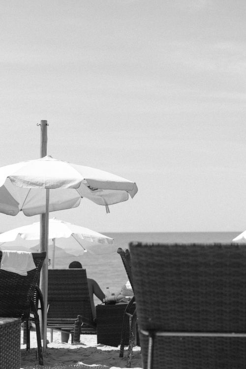 Free Monochrome beach view in Porto Seguro, Bahia, featuring chairs and umbrellas. Stock Photo