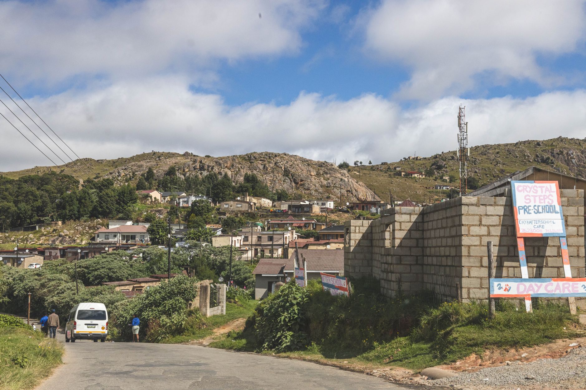 A picturesque view of a village in the mountainous region of Eswatini with clear blue skies.