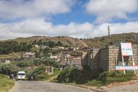 A picturesque view of a village in the mountainous region of Eswatini with clear blue skies.