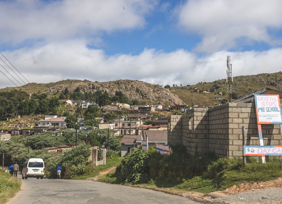 A picturesque view of a village in the mountainous region of Eswatini with clear blue skies.