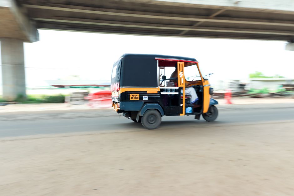 An auto-rickshaw with an Uber sticker on a street in an Indian city