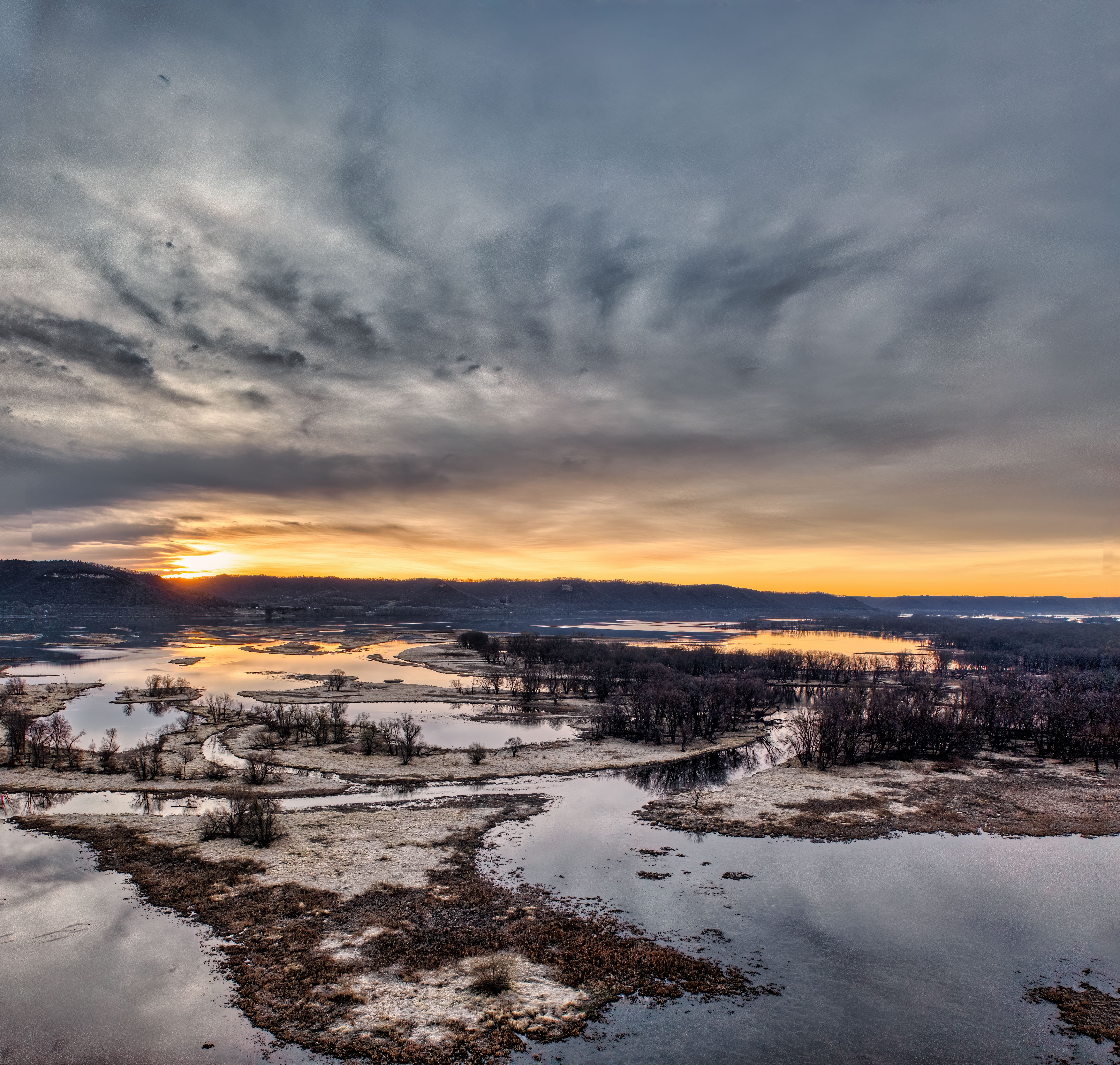Beautiful sunset view of the Mississippi River in Nelson, Wisconsin with reflective waters and dramatic skies.