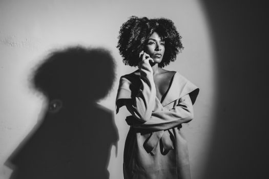Artistic black and white portrait of a woman in thoughtful pose with dramatic shadow.