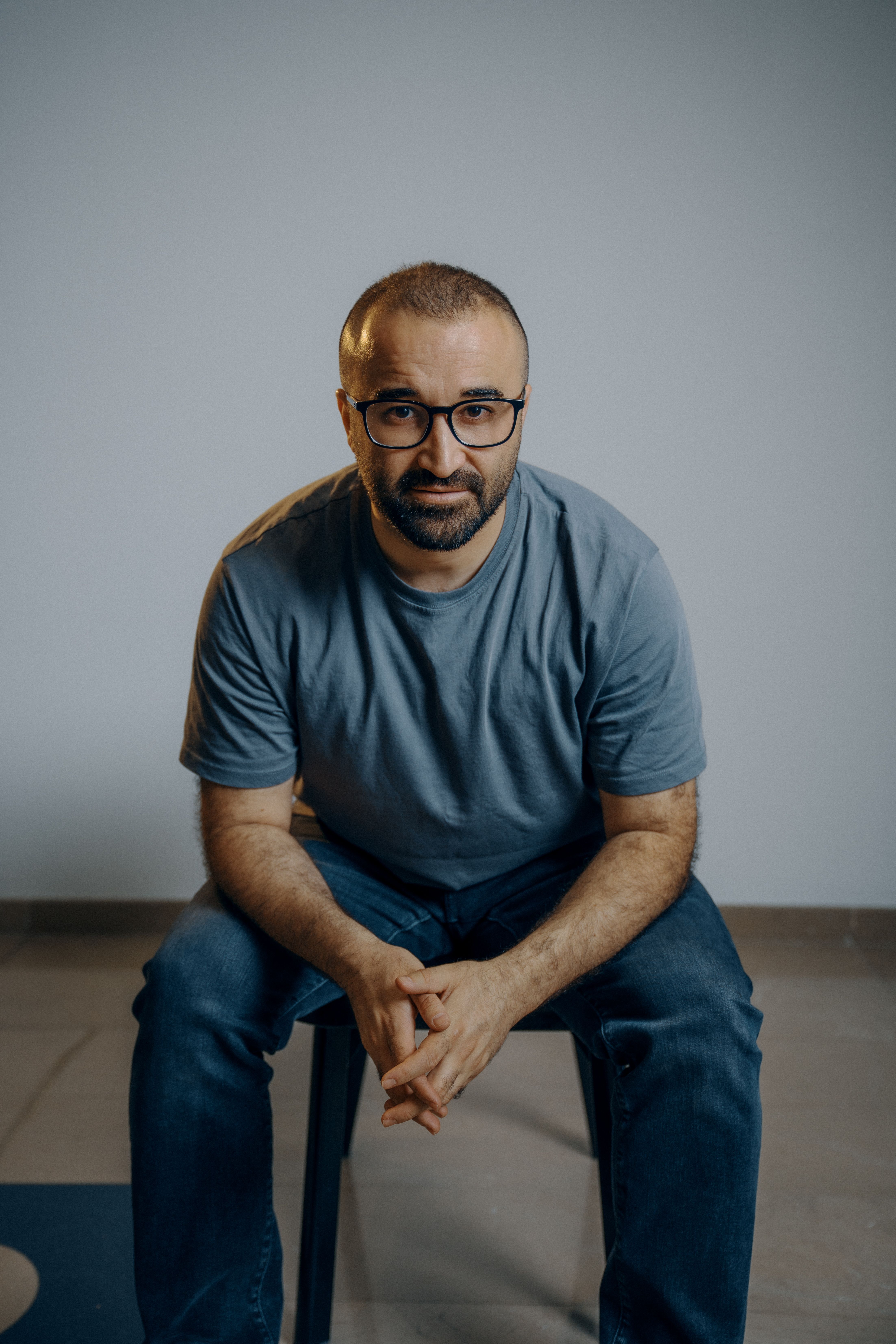 Male sitting on a chair in a minimalistic studio setting, Erbil Governorate, Iraq.
