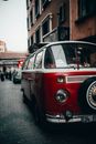 Retro minibus parked near old building on pavement in town