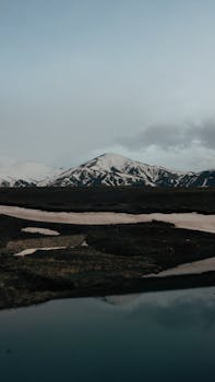 Dramatic view of snow-capped mountains and serene lake reflections.