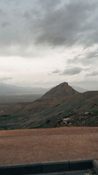 A tranquil mountain landscape with cloudy skies creating a moody atmosphere.