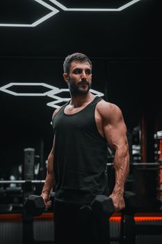 Muscular man lifting weights in a modern gym, intense workout session.