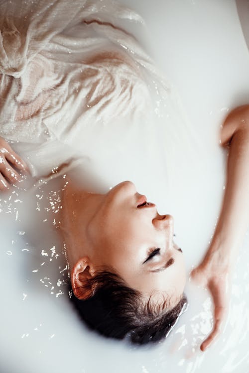 Woman Relaxing In A Tub Of Milk Bath